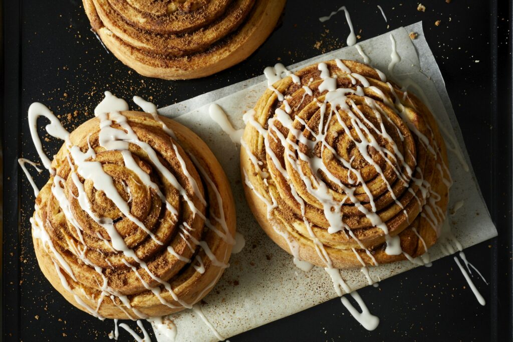 Cinnamon Rolls drizzled with Icing on wax paper